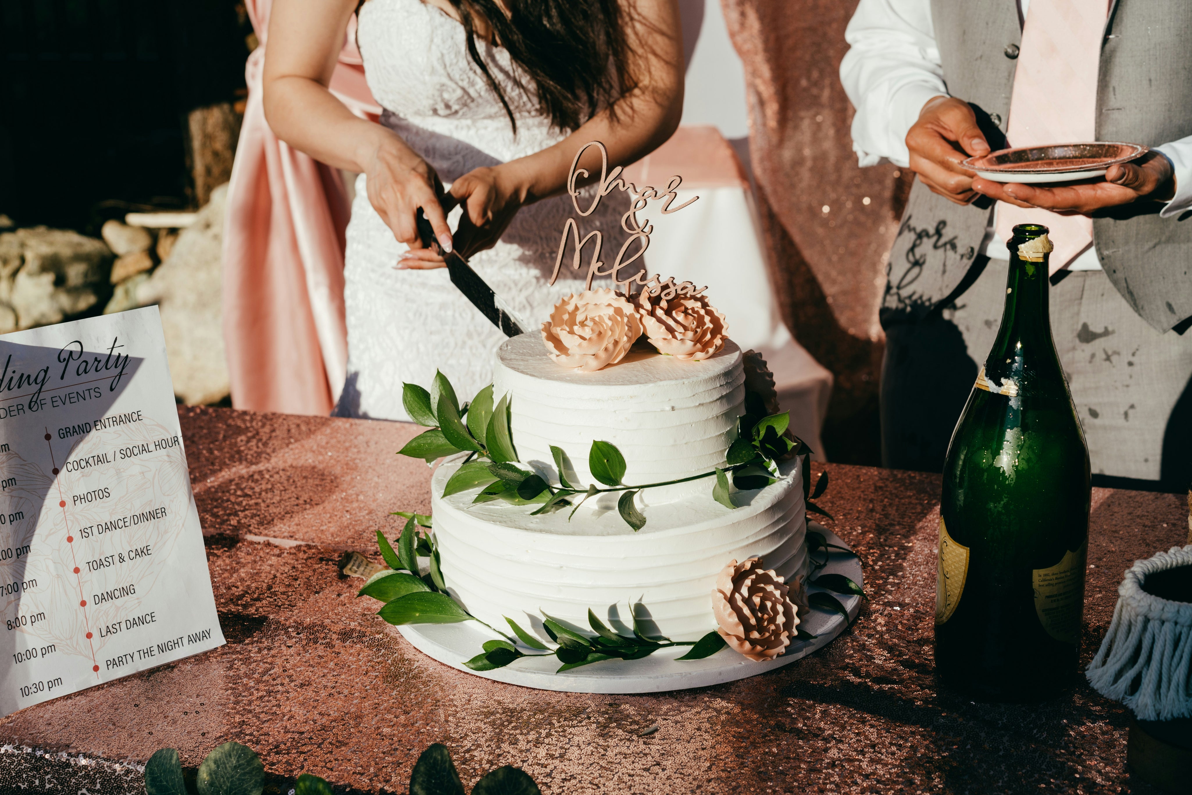 Wedding cake being sliced by bride